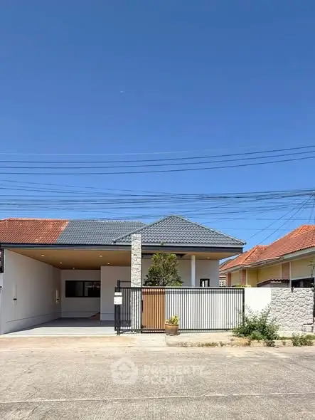 Charming single-story home with modern facade and spacious driveway under clear blue sky.