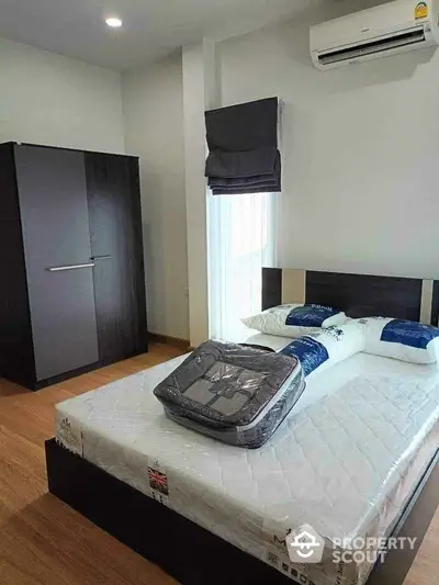 Modern bedroom with sleek furniture and air conditioning, featuring a comfortable bed and stylish wardrobe.