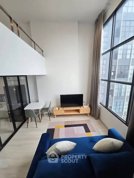 Modern loft living room with high ceilings and large windows