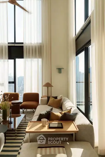 Luxurious high-ceiling living room with floor-to-ceiling windows and modern decor.
