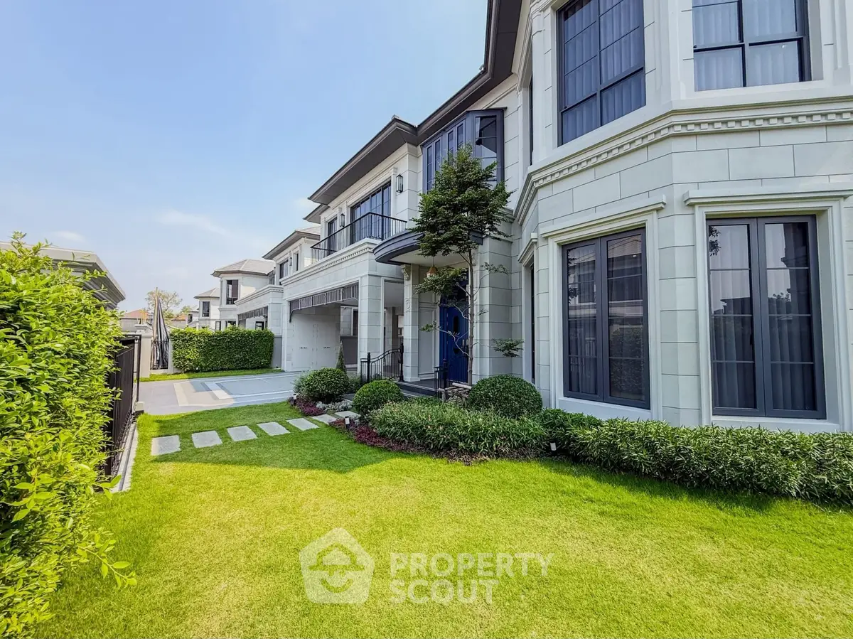 Luxurious modern home with manicured lawn and elegant facade in a serene neighborhood.