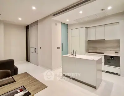 Modern open-layout kitchen with sleek white cabinetry and island in a contemporary apartment.