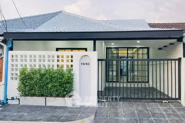 Charming single-story home with modern facade and gated entrance, perfect for cozy living.