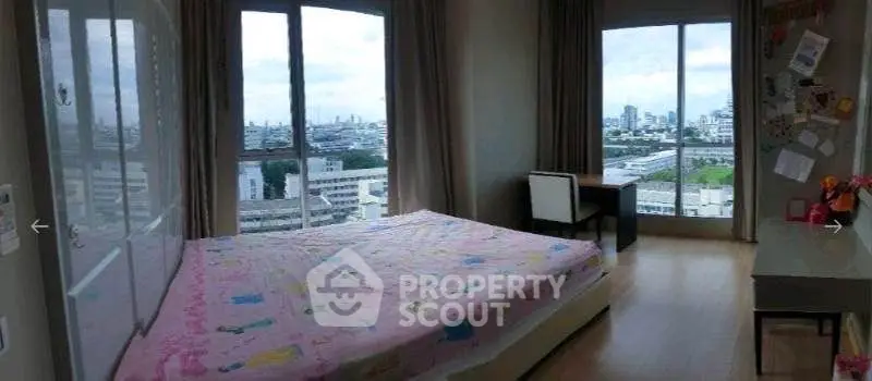 Spacious bedroom with panoramic city views and ample natural light