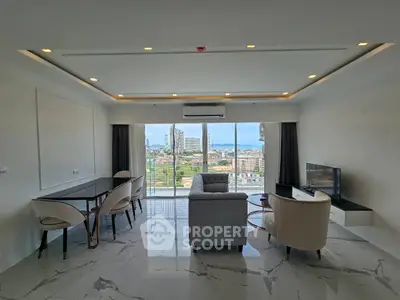 Spacious living room with stunning city and ocean view, modern furniture, and elegant decor.