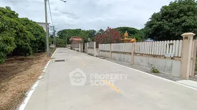 Charming suburban street view with lush greenery and fenced properties, ideal for peaceful living.