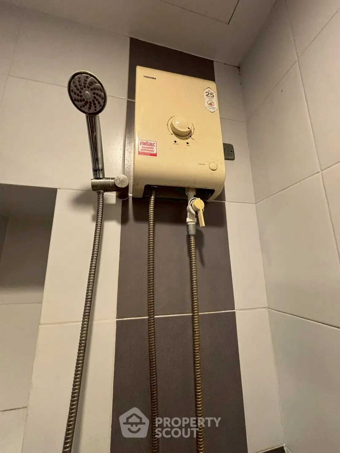 Modern bathroom with water heater and shower head, ideal for comfort and convenience.