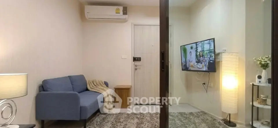 Cozy living room with modern decor and wall-mounted TV in a stylish apartment.