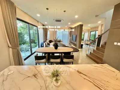 Luxurious open-plan living room with elegant decor and garden view