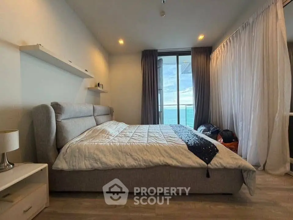 Spacious bedroom with ocean view and modern decor in luxury apartment