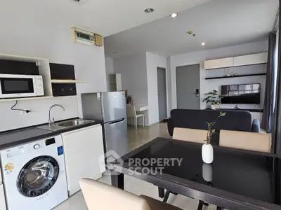 Modern open-plan living room with kitchen, dining area, and stylish furniture in a contemporary apartment.