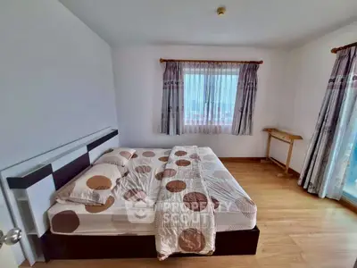 Spacious bedroom with modern decor and large window for natural light