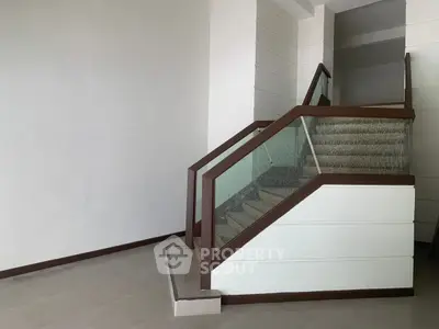 Modern staircase with glass railing in a minimalist interior design