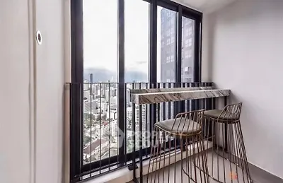 Modern balcony with city view and stylish bar stools in high-rise apartment.