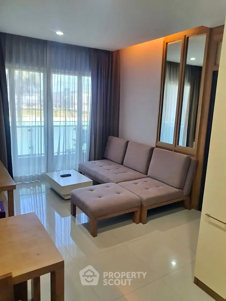 Modern living room with elegant sofa and large window offering natural light.
