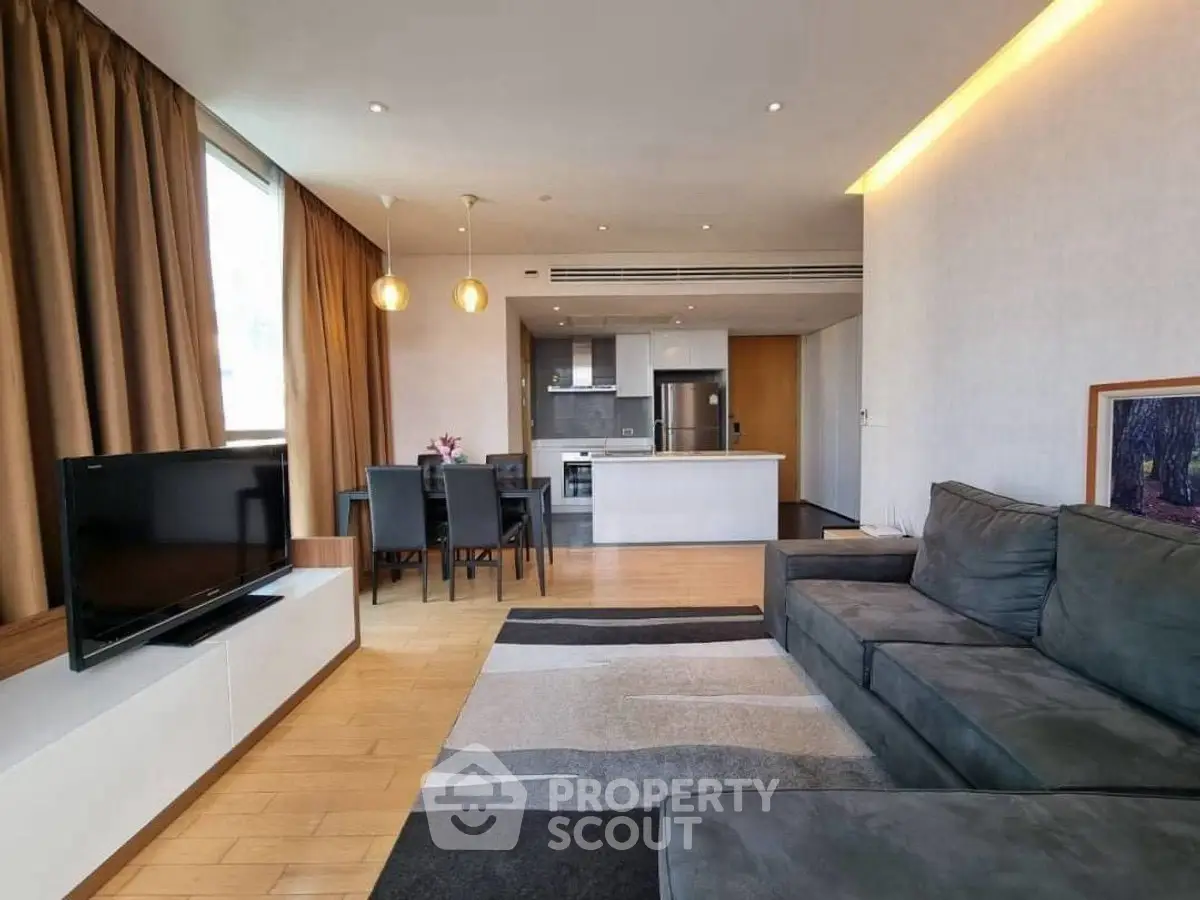 Modern open-plan living room with sleek kitchen and cozy seating area