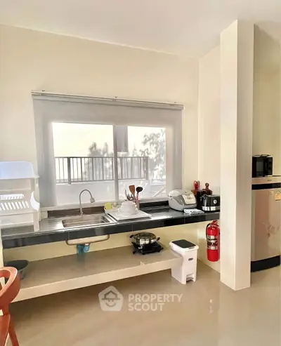 Modern kitchen with sleek countertops and essential appliances, perfect for culinary enthusiasts.