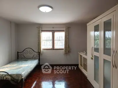 Spacious bedroom with natural light and wooden flooring