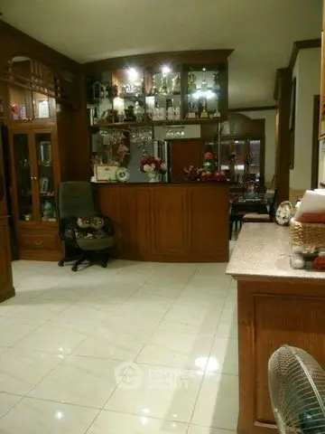 Spacious living room with elegant wooden cabinetry and tiled flooring