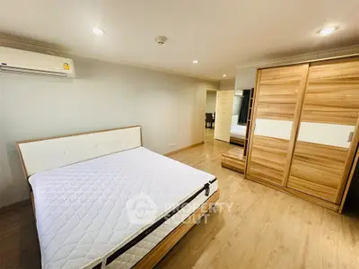 Spacious bedroom with modern wooden wardrobe and cozy lighting