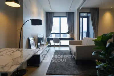 Modern living room with stylish decor and large windows offering natural light.