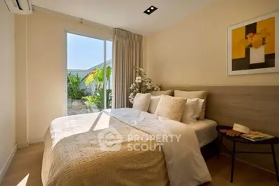 Cozy bedroom with natural light and garden view, featuring elegant decor and plush bedding.