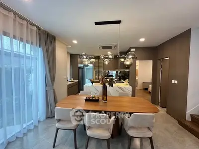 Modern dining area with elegant lighting and open kitchen layout