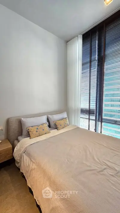 Modern bedroom with large windows and stylish decor in a luxury apartment.