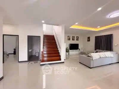 Spacious modern living room with sleek staircase and cozy seating area