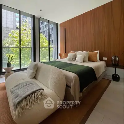 Luxurious modern bedroom with large windows and elegant decor in urban setting.