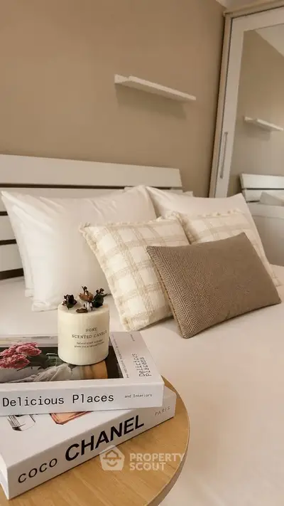 Cozy bedroom with stylish decor, featuring a comfortable bed, elegant pillows, and chic bedside table accents.