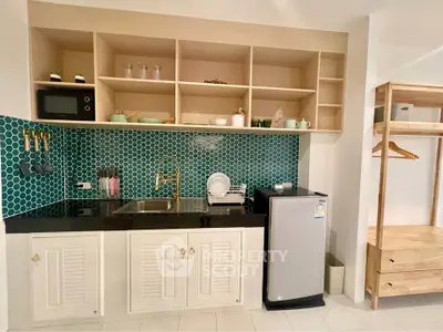 Charming kitchen with open shelving and modern appliances, featuring a stylish backsplash and compact fridge.