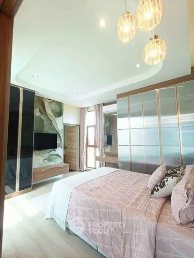 Luxurious bedroom with modern decor and ample natural light, featuring stylish lighting and elegant furnishings.