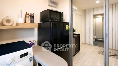 Modern compact kitchen with appliances and washing machine in stylish apartment