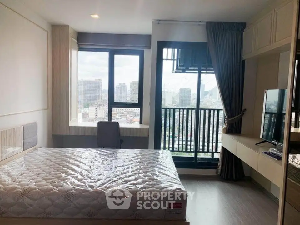 Modern bedroom with city view and balcony access in high-rise apartment