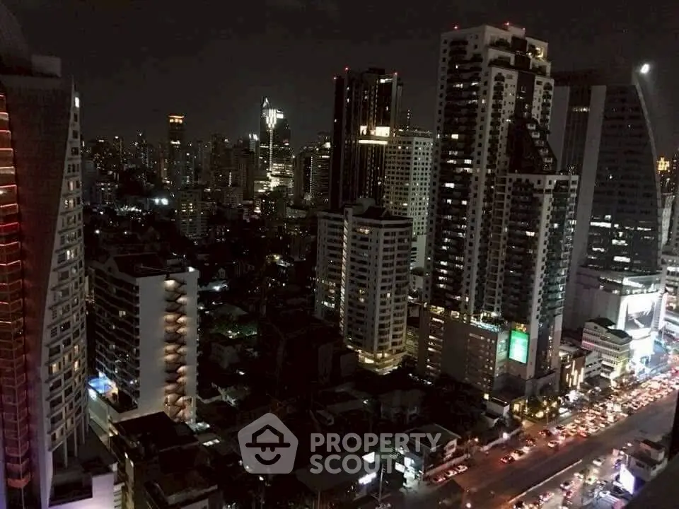 Stunning nighttime cityscape view with illuminated skyscrapers and bustling streets.