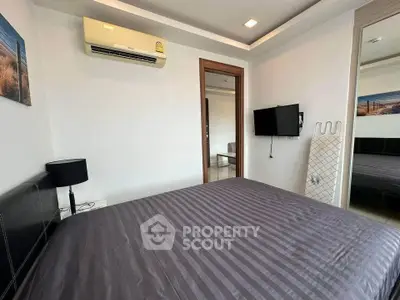 Modern bedroom with air conditioning and wall-mounted TV in stylish apartment.
