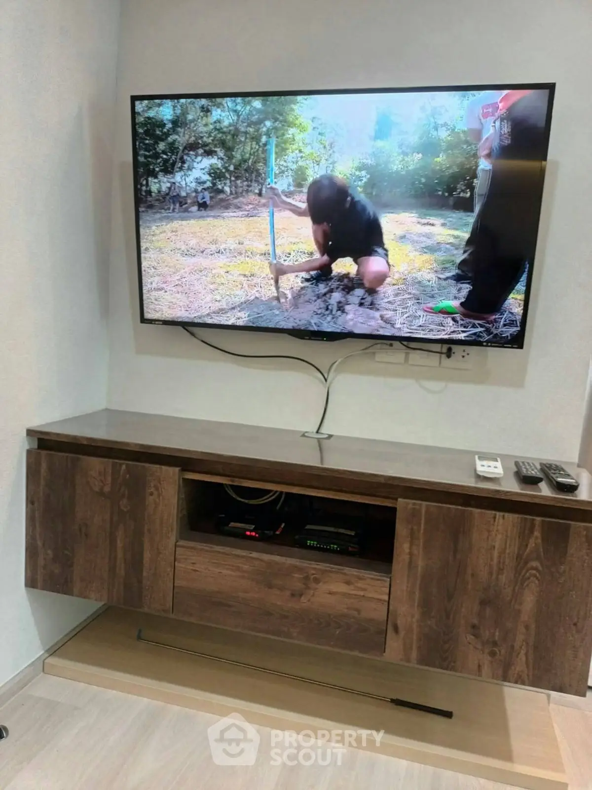 Modern living room with wall-mounted TV and stylish wooden cabinet