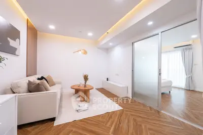 Modern living room with elegant decor and sliding glass door leading to bedroom