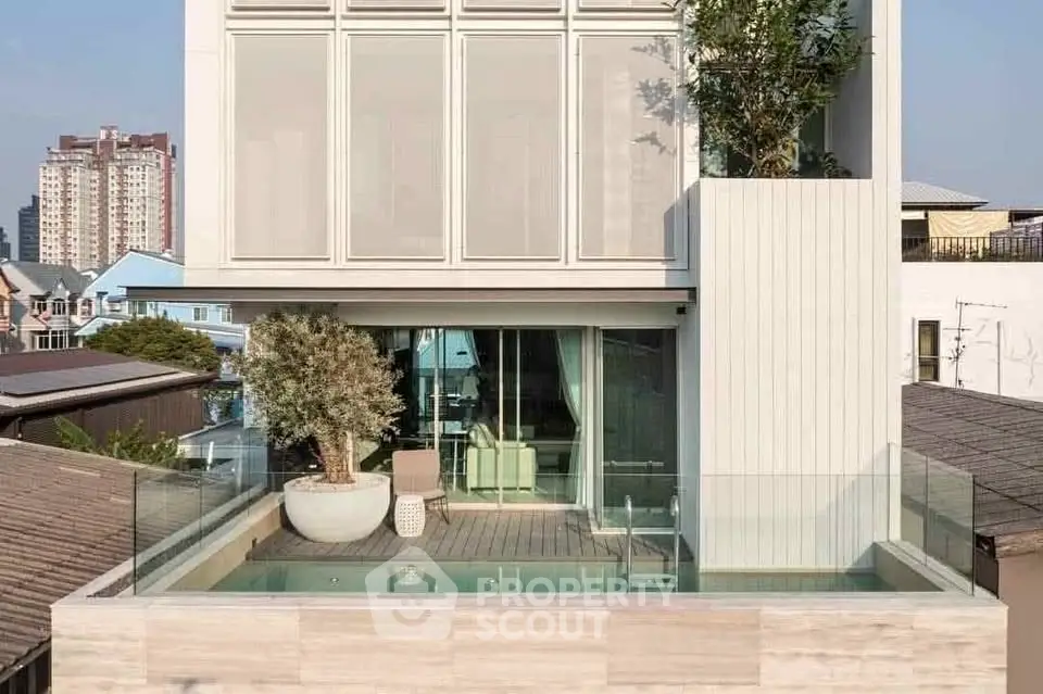 Modern urban building with rooftop pool and glass railing, offering a luxurious city living experience.