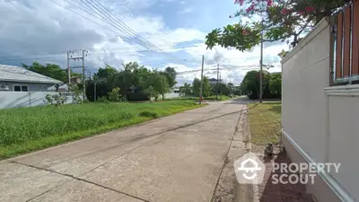 Charming suburban street view with lush greenery and clear skies, perfect for tranquil living.