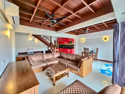 Spacious living room with modern furniture and wooden ceiling accents