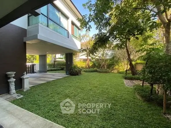 Luxurious modern home with lush green garden and spacious outdoor area, perfect for relaxation and entertaining.
