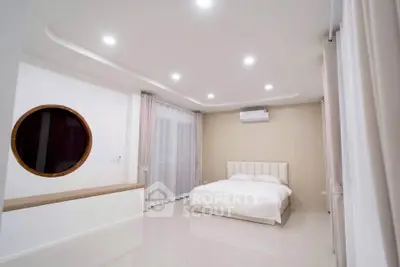 Spacious modern bedroom with elegant lighting and unique circular window design.