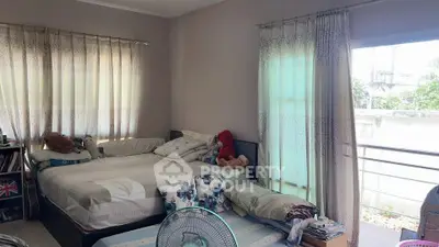 Cozy bedroom with large windows and balcony access, perfect for relaxation and natural light.