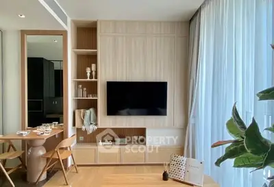 Modern living room with stylish decor and large window drapes, featuring a wall-mounted TV and elegant shelving.