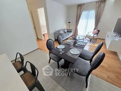 Modern living room with dining area, featuring elegant furniture and natural light.