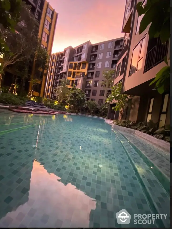 Luxurious apartment complex with stunning pool and modern architecture at sunset