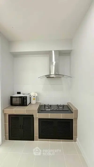 Modern kitchen with gas stove and microwave in compact layout