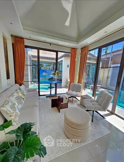 Luxurious living room with pool view, modern furniture, and abundant natural light.